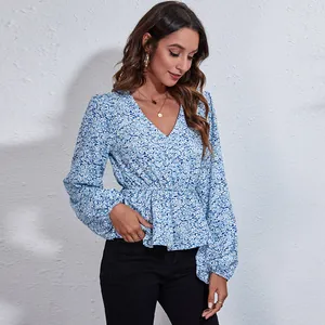 Elegant blue floral print V-neck blouse with lantern sleeves and cinched waist detail.