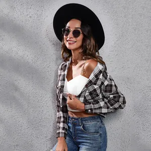 Stijlvol zwart-wit geruit cropped shirt met lange mouwen gedragen met jeans