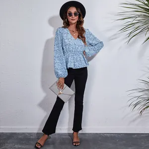 Detail showing the elegant floral print and V-neck design of the light blue women's top.