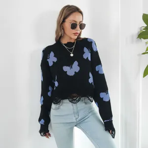 Close-up of Y2K black distressed sweater featuring blue butterfly jacquard pattern.