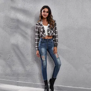 Stijlvolle cropped geruit overhemdjack met skinny jeans en zwarte laarzen detail