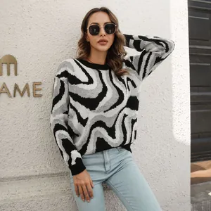 Detailed shot of woman in black and white swirl jacquard knit sweater outdoors