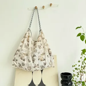 Large capacity canvas tote bag with artistic brown butterfly print hanging in a room.