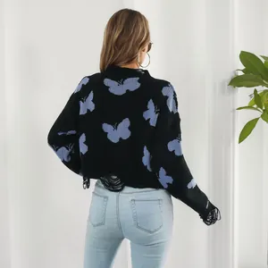 Detail of Y2K distressed cropped sweater featuring blue butterfly jacquard and frayed edges