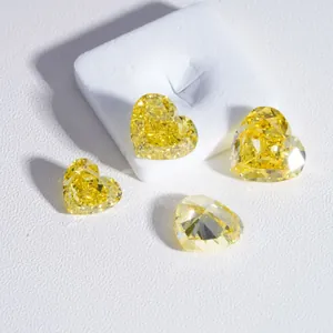 Macro view of four sparkling heart-shaped fancy vivid yellow lab-grown diamonds.