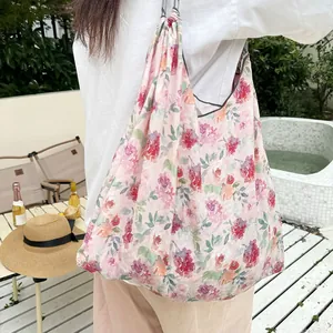 Detailed view of large floral print canvas tote bag carried on shoulder for resort beach style