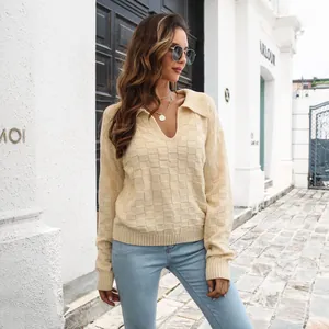Dettaglio maglione in maglia crema con scollo a V, trama a scacchi 3D e colletto a polo