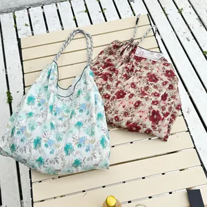 Detailed view of floral canvas tote bags with blue and red patterns on wood surface