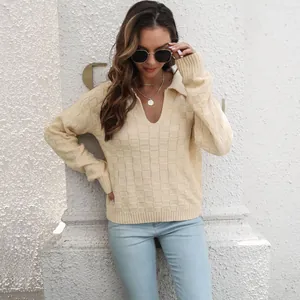 Dettaglio di un maglione a maglia a scacchi 3D crema con un elegante colletto polo.