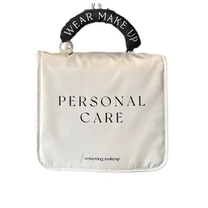 Elegante beige Kosmetiktasche mit großem Perlengriff und Personal Care Aufdruck