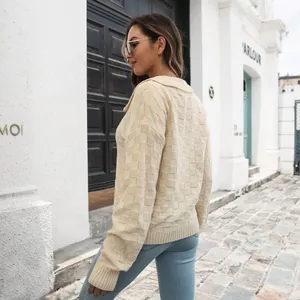Vista posteriore di un maglione polo da donna color crema con motivo a scacchi 3D
