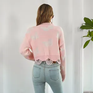 Back view of a pink Y2K cropped knit sweater with white butterfly jacquard and ripped hem.
