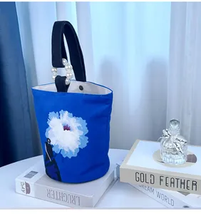 Blauwe canvas bucket bag met artistieke bloemenprint en elegant handvat met parels