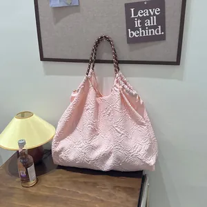 Sac à main rose texturé à fleurs dans un intérieur de maison chaleureux et chic