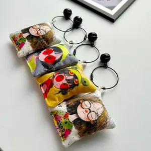 Detalle de dijes de lona para bolsos con ilustraciones coloridas de niñas de dibujos animados