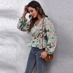 Stylish floral print v-neck top with puff sleeves and cinched waist on a fashion model.
