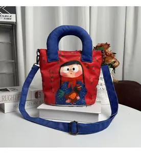Detailed close-up of a red canvas bucket bag featuring a hand-drawn girl design