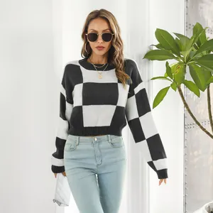 Primo piano di una modella che indossa un maglione corto a scacchi bianco e nero trendy