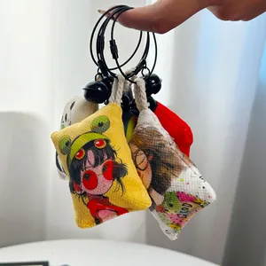 Vista detallada de coloridos colgantes para bolso de lona con dibujos de tendencia