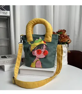 Close-up of a cute dark green canvas bucket bag with yellow handle and hand-painted girl print