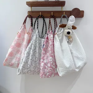 Quatre sacs à main en tissu aux motifs floraux variés suspendus à un support en bois