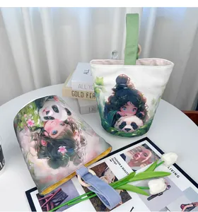 Detail view of canvas bucket bags featuring cute panda and girl illustrations with wooden ring straps