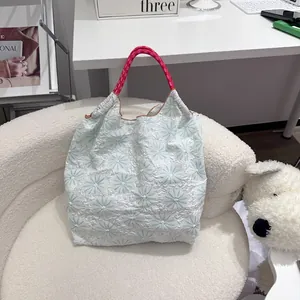 Détail d'un sac cabas à fleurs fraîches avec poignées en corde rose tressée
