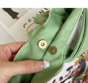 Detailed macro view of the magnetic snap closure on a panda printed canvas bucket handbag