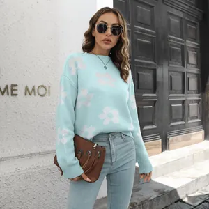 Streetstyle-weergave van een vrouw in een blauwe jacquardtrui met witte madeliefjespatroon