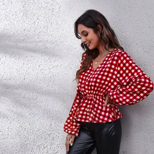 Side view of a red checkered peplum blouse with lantern sleeves and V-neckline