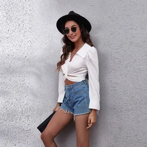 Elegant white cropped blouse with front twist and puff sleeves in lifestyle outdoor setting
