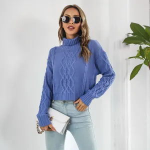 Close-up of blue cable-knit turtleneck sweater showing texture and cropped fit