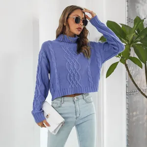 Close-up of a lavender blue cable-knit turtleneck sweater worn with light denim jeans