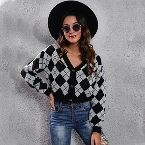 Detail of black and white argyle knitted cropped cardigan with elegant button closure