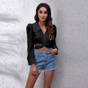 Detailed view of a black cropped puff sleeve shirt featuring a chic front cross knot