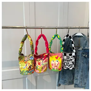 Vista detallada de cuatro bolsos de lona con dibujos animados en un perchero de ropa.