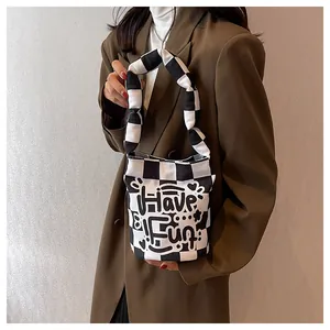 Vista detallada del bolso tote de lona de cuadros blancos y negros con grafiti