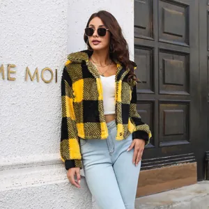 Close-up view of a yellow and black plaid fleece jacket worn by a model in a street setting