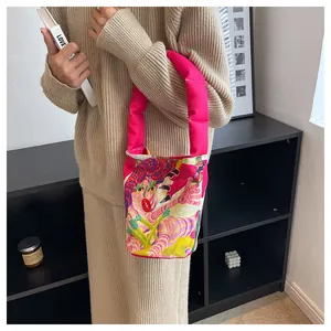Detalle de un bolso de lona con dibujos animados vibrantes llevado por una modelo