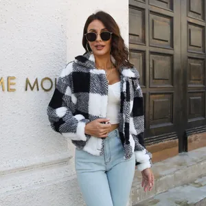 Close-up of stylish black and white buffalo plaid fuzzy fleece jacket on a model outdoors