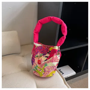 Detalle de bolso de lona con dibujos animados, asa acolchada rosa y gráfico vibrante