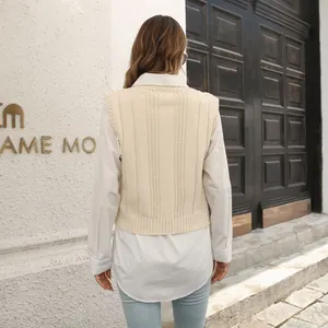 Vue arrière d'un élégant pull sans manches en maille torsadée crème sur une chemise blanche