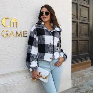 Stylish woman in black and white plaid fuzzy jacket paired with light blue denim jeans.