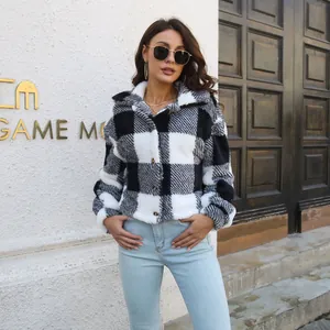 Detailed fashion view of a woman wearing a stylish black and white plaid fuzzy jacket