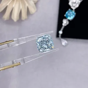 Close-up macro view of a sparkling cushion-cut blue lab-grown diamond held by tweezers