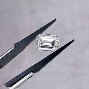 Macro detail of emerald cut lab-grown diamond held by professional black jewelry tweezers.