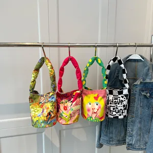 Colección de coloridas bolsas de lona con dibujos animados colgadas en un estante de metal