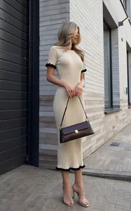 Elegant cream ribbed knit bodycon midi dress featuring black contrast ruffle edges