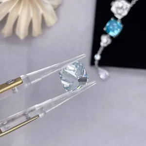 Detailed macro shot of a light blue cushion-cut lab-grown diamond held by jewelry tweezers