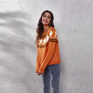 Close-up view of woman wearing orange Halloween ghost knit sweater with retro patterns